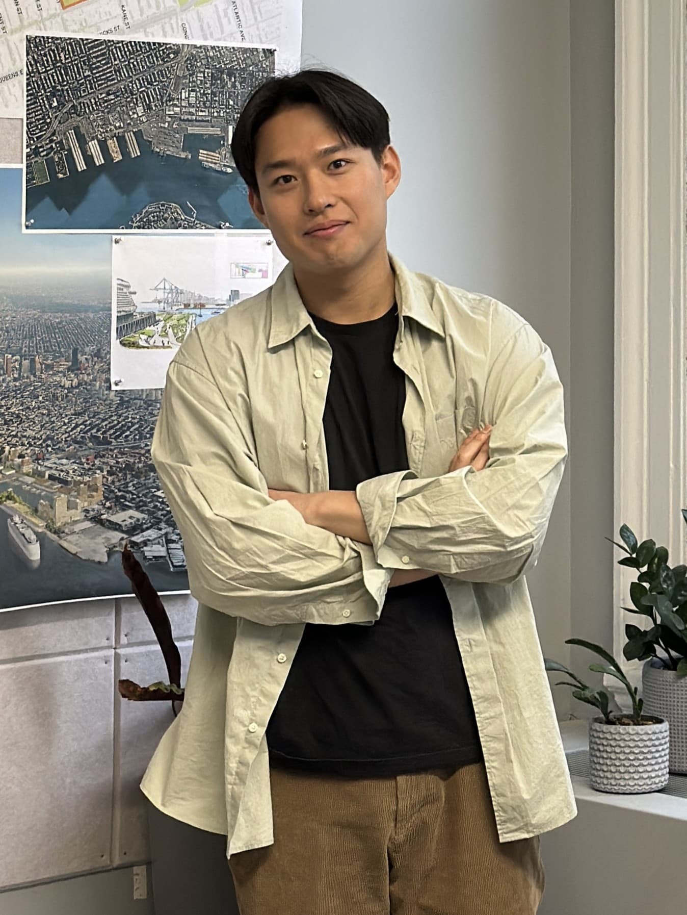 David Cho, standing in front of a board of site plans and aerial photographs